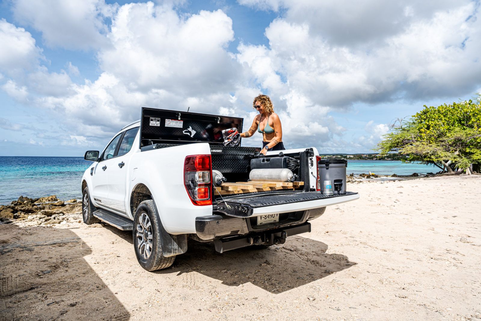 Diver at the open lockbox, with tank rack and hydration station on the truck bed